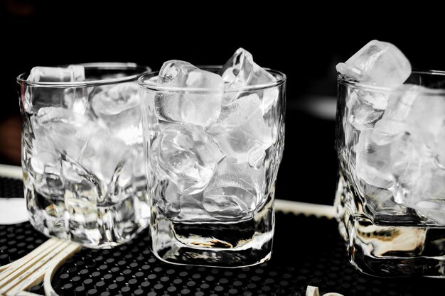 glasses with ice cubes are on the bar glasses with ice on a black background