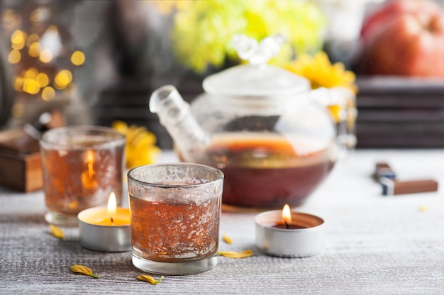 Glasses with lit candles and tea pot 