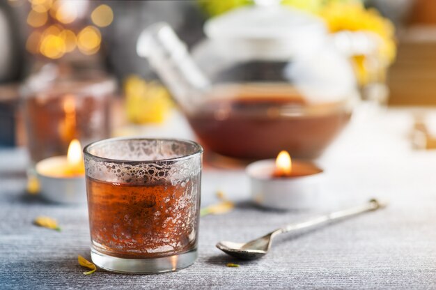 Glasses with lit candles and tea pot 