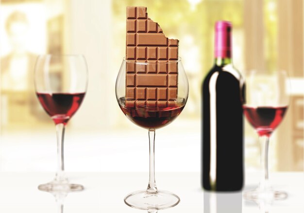 Glasses with red wine and chocolate bar