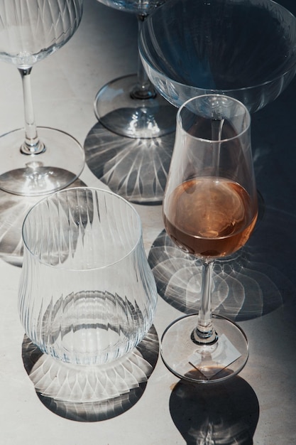 Бокалы с розовым вином на каменном фоне Стиль плоской планировки Тенденция контрастных теней