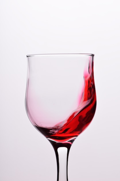 Glasses with waves plash of red wine on a white background