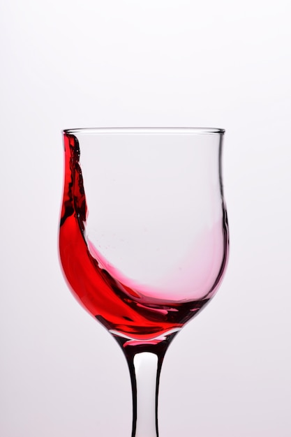 Glasses with waves plash of red wine on a white background