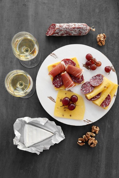 写真 灰色の背景に白ワイン グレープ ソーセージとチーズのグラス