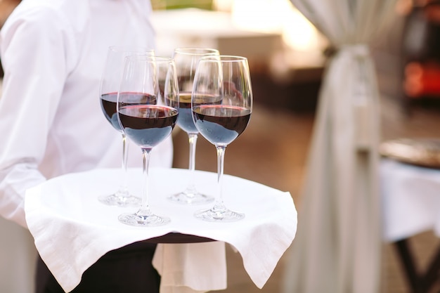 Glasses with wine on a tray. Meeting with guests.