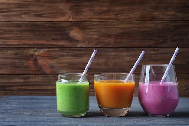 Glasses with yummy smoothie on wooden background