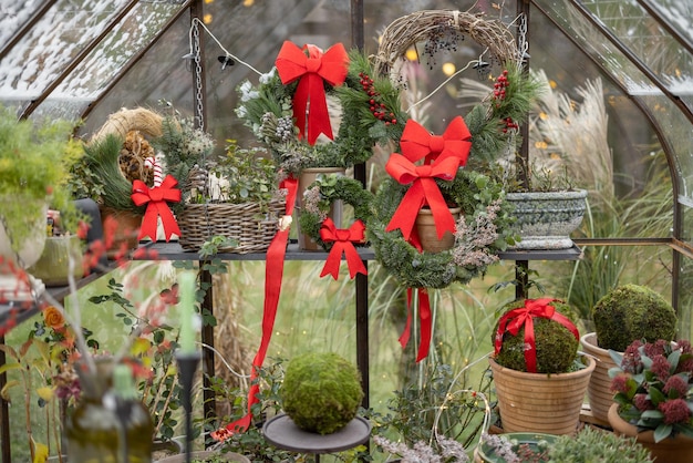 冬の休暇のために花輪と赤い弓で飾られたグラスハウス