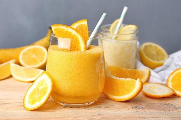 Glassware with different smoothies on wooden table