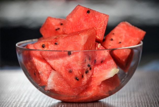 Glassware with juicy and sweet watermelon cubes on a wooden table Slices of sweet juicy watermelon