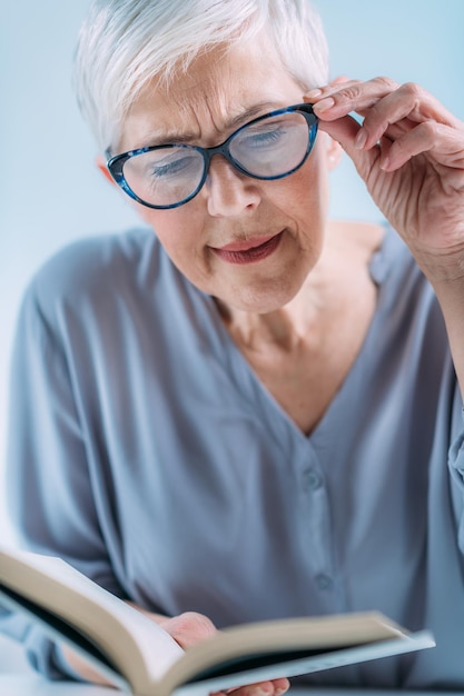 Photo glaucoma senior woman a reading book having ocular tension