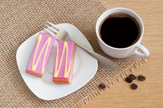 Glazed cakes with a coffee cup on the table