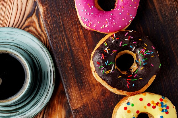 Glazed donut on green plate with cup of coffee