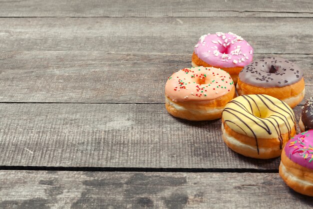 Glazed donuts on wooden surface