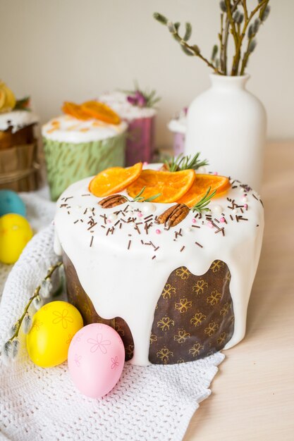 Foto torta di pasqua lustrata decorata con le arance e le uova sulla tavola di legno buone vacanze di pasqua