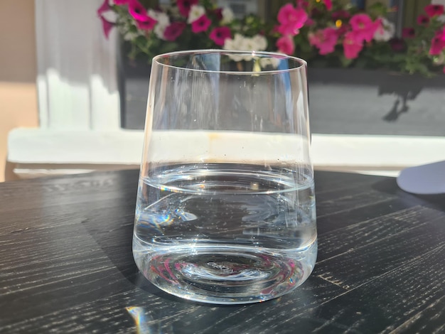 Glazen beker met schoon water op tafel in straatcafé