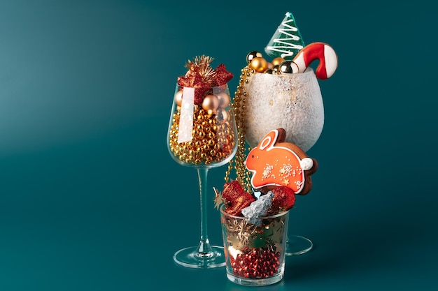 Glazen bekers met kerstdecor tegen donkergroene achtergrond