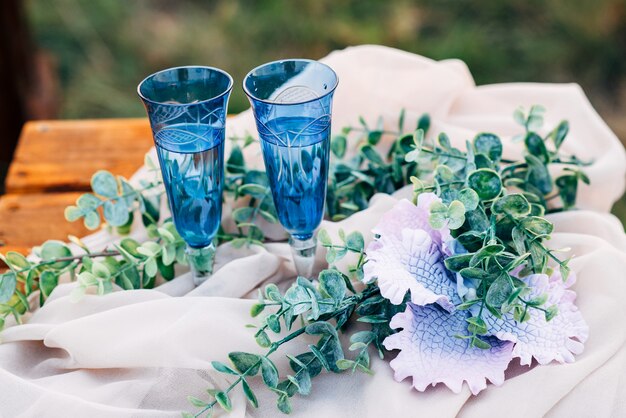 Glazen blauw naast bloemen op tafel