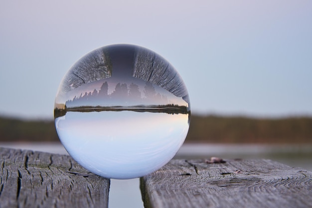 Glazen bol op een houten pier bij een Zweeds meer op avonduur Natuur Scandinavië