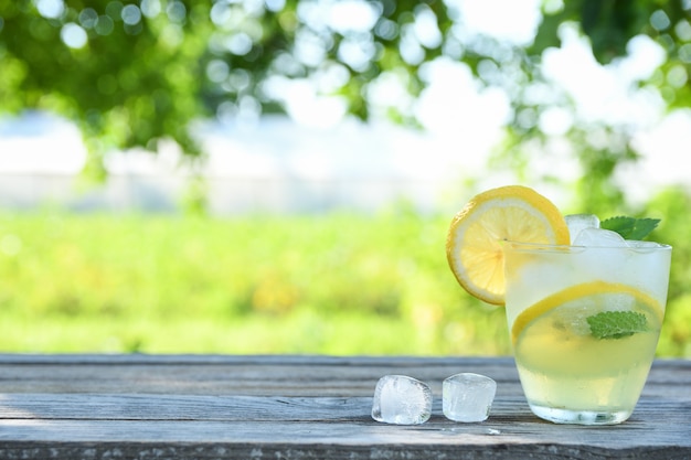 Glazen citroensap op een houten tafel, zomer set, outdoor hebzucht blured, boke. water detox