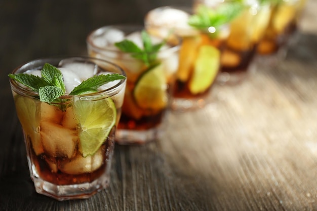 Glazen cocktail met ijs en munt op houten ondergrond