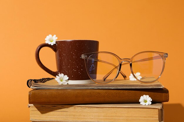 Glazen en beker op boeken op gele achtergrond