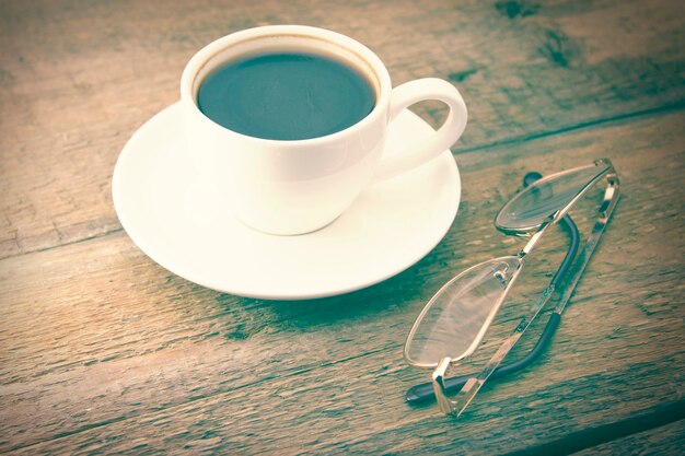 Glazen en kopje koffie op een houten tafel