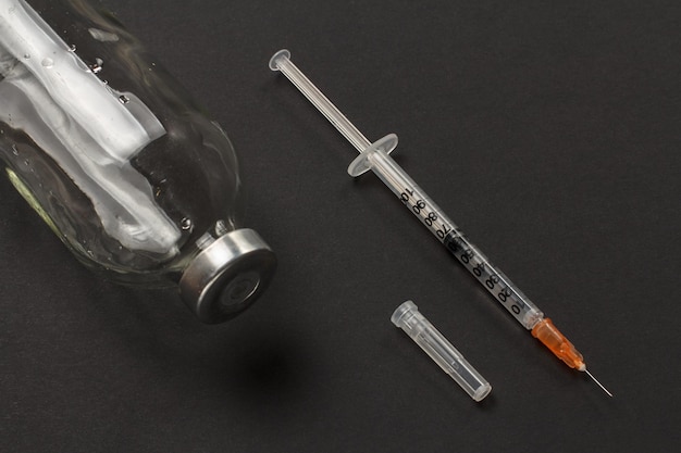 Glazen fles voor vloeibare medicijnen en een plastic spuit voor injectie Gezondheid en medisch concept