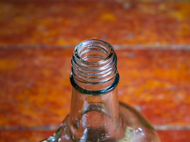 Glazen fles voor wodka met een handvat op een houten achtergrond