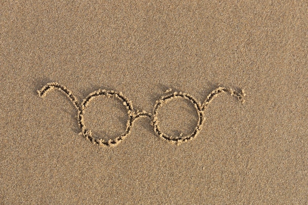 Glazen geschilderd in het zand.