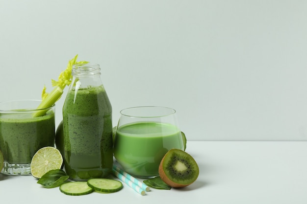 Glazen groene smoothie en ingrediënten op witte lijst