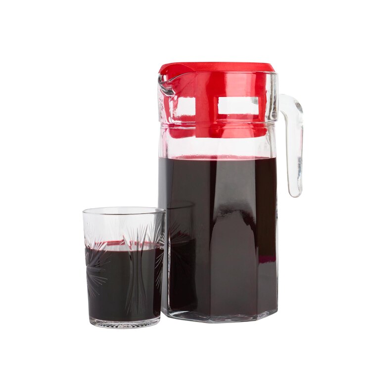 Glazen karaf en glas met vers sap van kamperfoelie bessen geïsoleerd op een witte achtergrond gezonde voeding