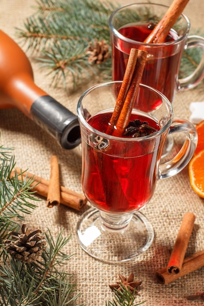 Glazen kerst glühwein met kruiden en sinaasappel op jute