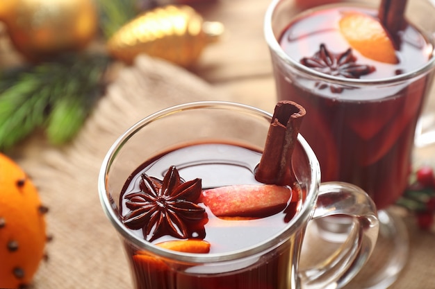 Glazen kopje heerlijke glühwein met kerstdecor op zak, close-up