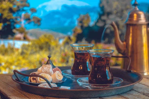 Glazen kopje Turkse thee geserveerd in traditionele stijl met zomers uitzicht