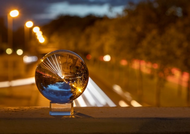 glazen kristallen bol reflectie van de nacht stad en weg