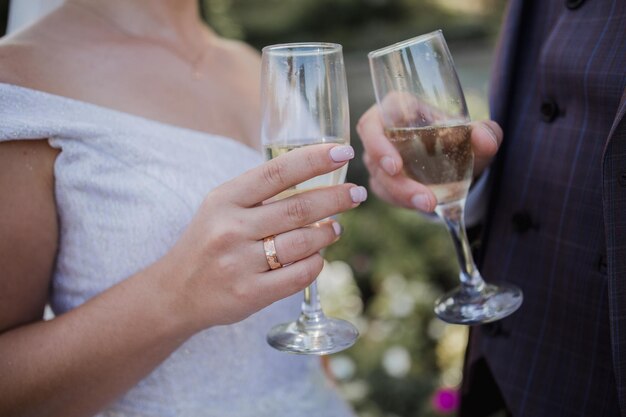 Glazen met champagne in de handen op bruiloft