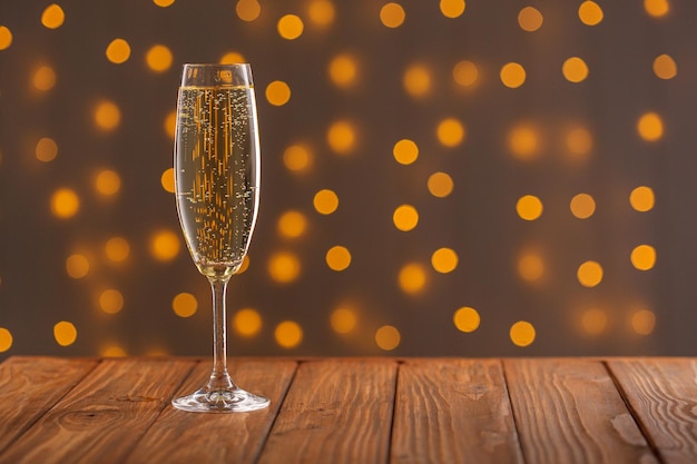 Glazen met champagne op een houten achtergrond tegen de achtergrond van een bokeh van lichten