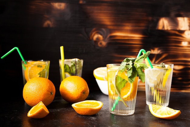 Glazen met orangeade en limonade op donkere vintage houten achtergrond