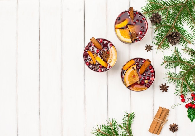 Glazen met traditionele kerstdrank op witte houten achtergrond Bovenaanzicht met kopieerruimte