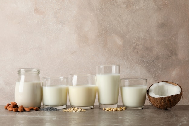 Glazen met verschillende soorten melk op bruine tafel