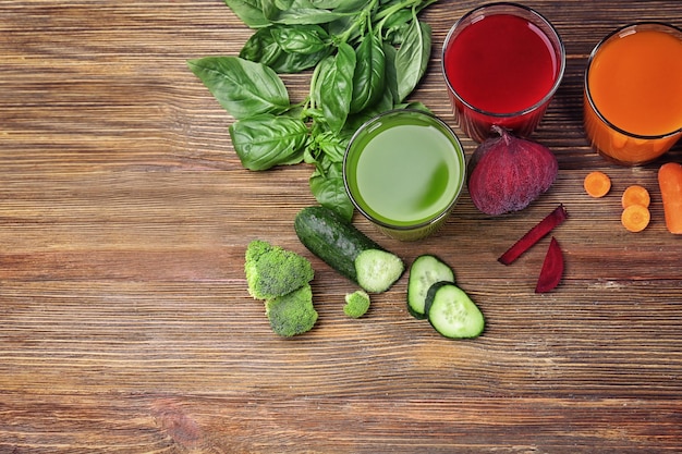 Glazen met verschillende verse sappen en ingrediënten op tafel