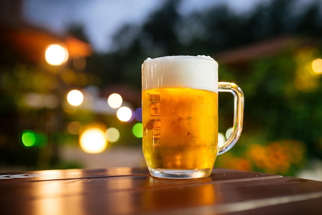 Glazen mok vers koud biertje in zomerterras