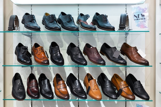Glazen planken met schoenen van man in een winkel