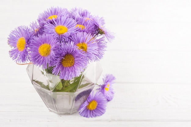 Glazen pot en paarse bloemen