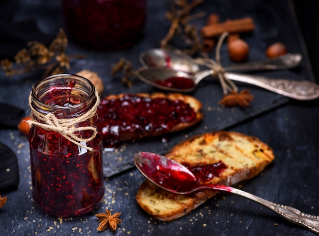 glazen pot met frambozenjam en een sneetje brood