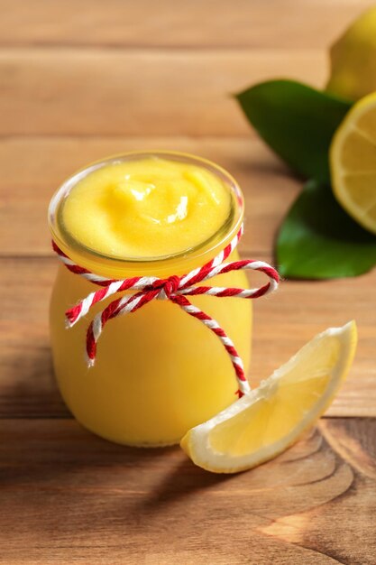 Glazen pot met lekkere lemon curd op houten tafel