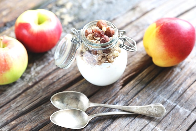 Glazen pot met yoghurtgranolla en amandelnoten erin