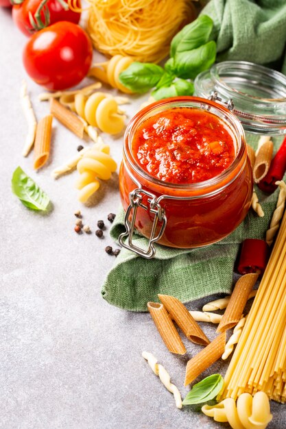 Glazen pot met zelfgemaakte klassieke pittige tomatenpasta of pizzasaus.