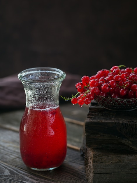 Glazen pot rode aalbes frisdrank drinken op donkere houten tafel. Zomer gezonde detox limonade, cocktail of een ander drankje