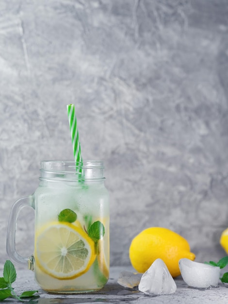 Glazen pot zomerverfrissende Mojito-limonade met citroenmunt en ijs